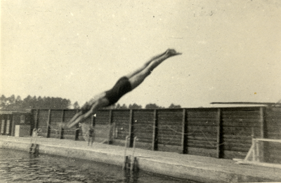 825379 Afbeelding van een jongen die een duik neemt in één van de zwembaden van Zweminrichting De Liesbosch ...